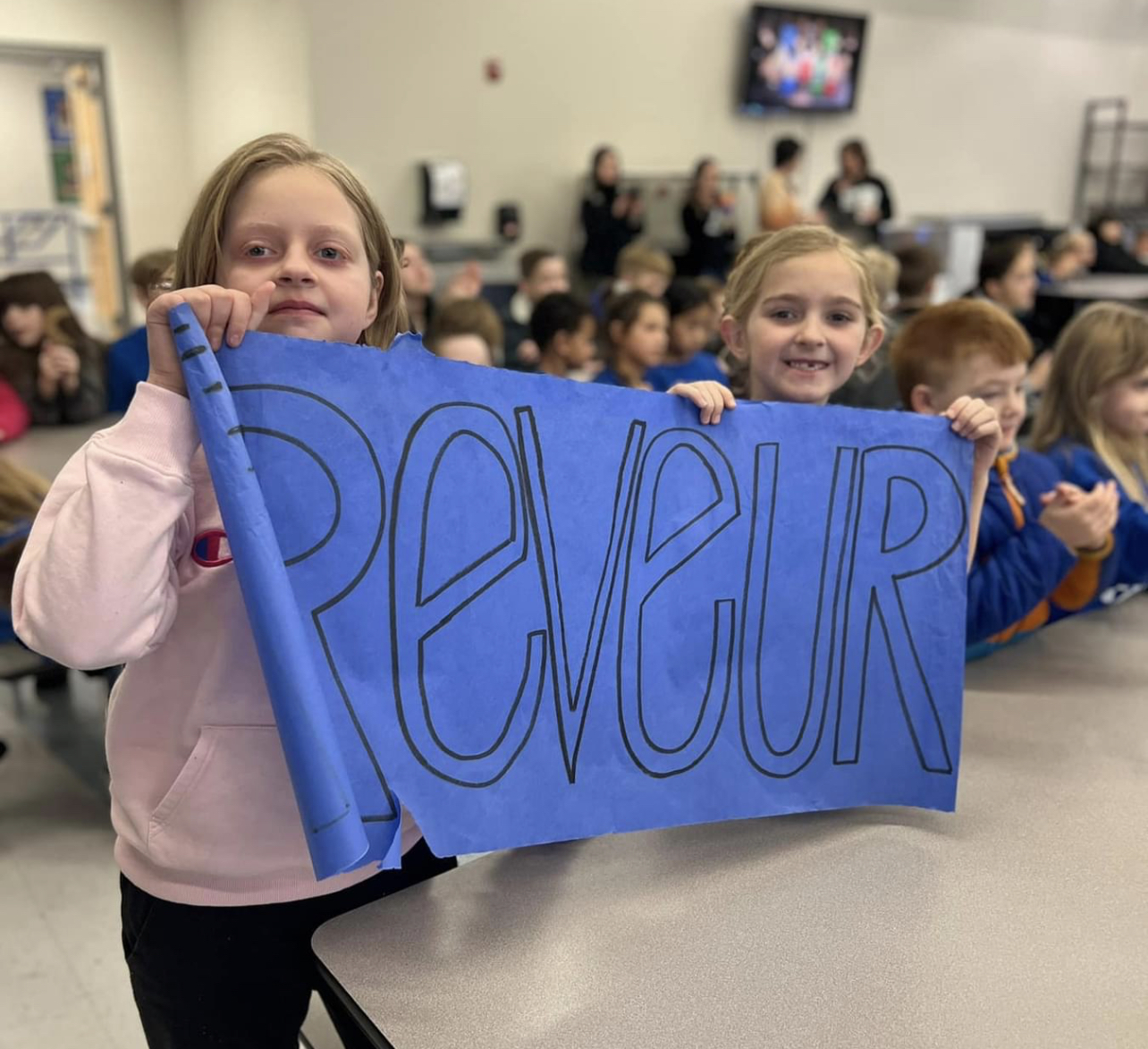 REVEUR STUDENTS HOLDING SIGN