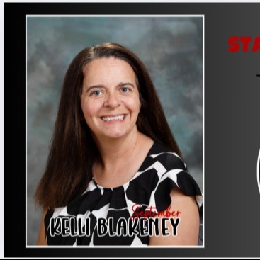 photo of teacher smiling with black and white shirt
