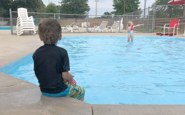 kid sitting on edge of wading pool