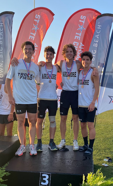 Group photo of cross country team standing by flags