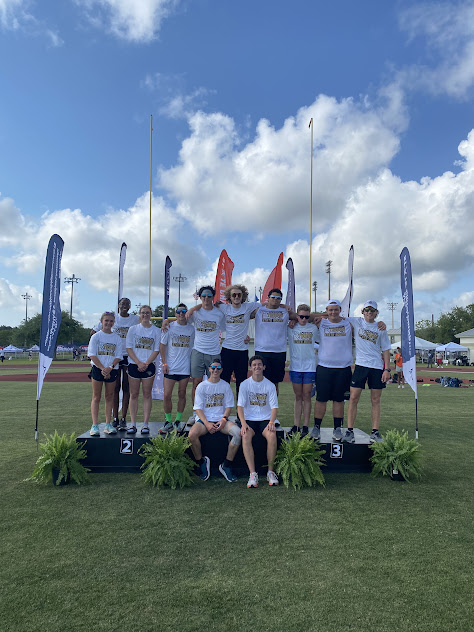 Group photo of cross country team standing by flags