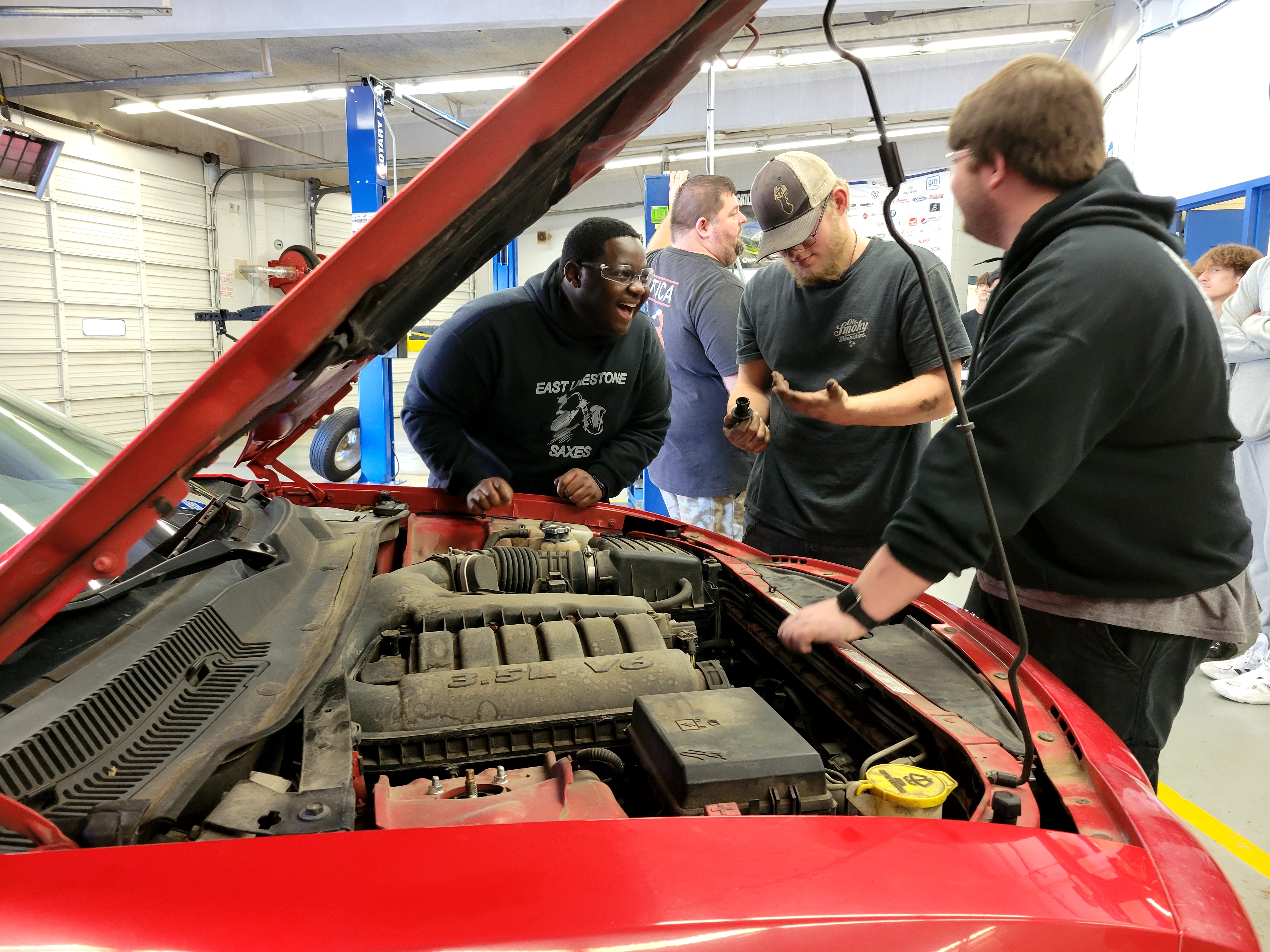 automotive students working on car engine