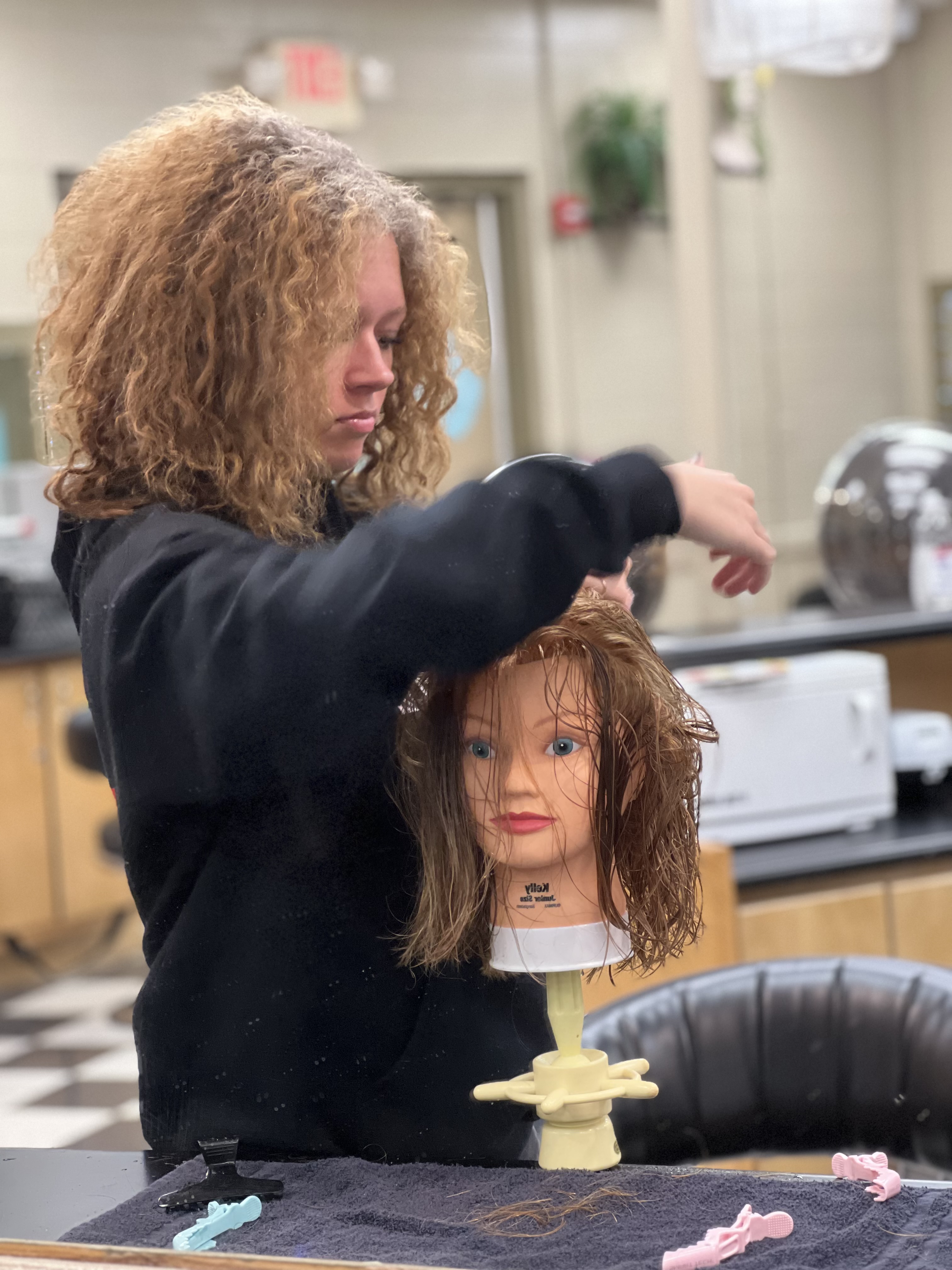 student cuts mannequin's hair