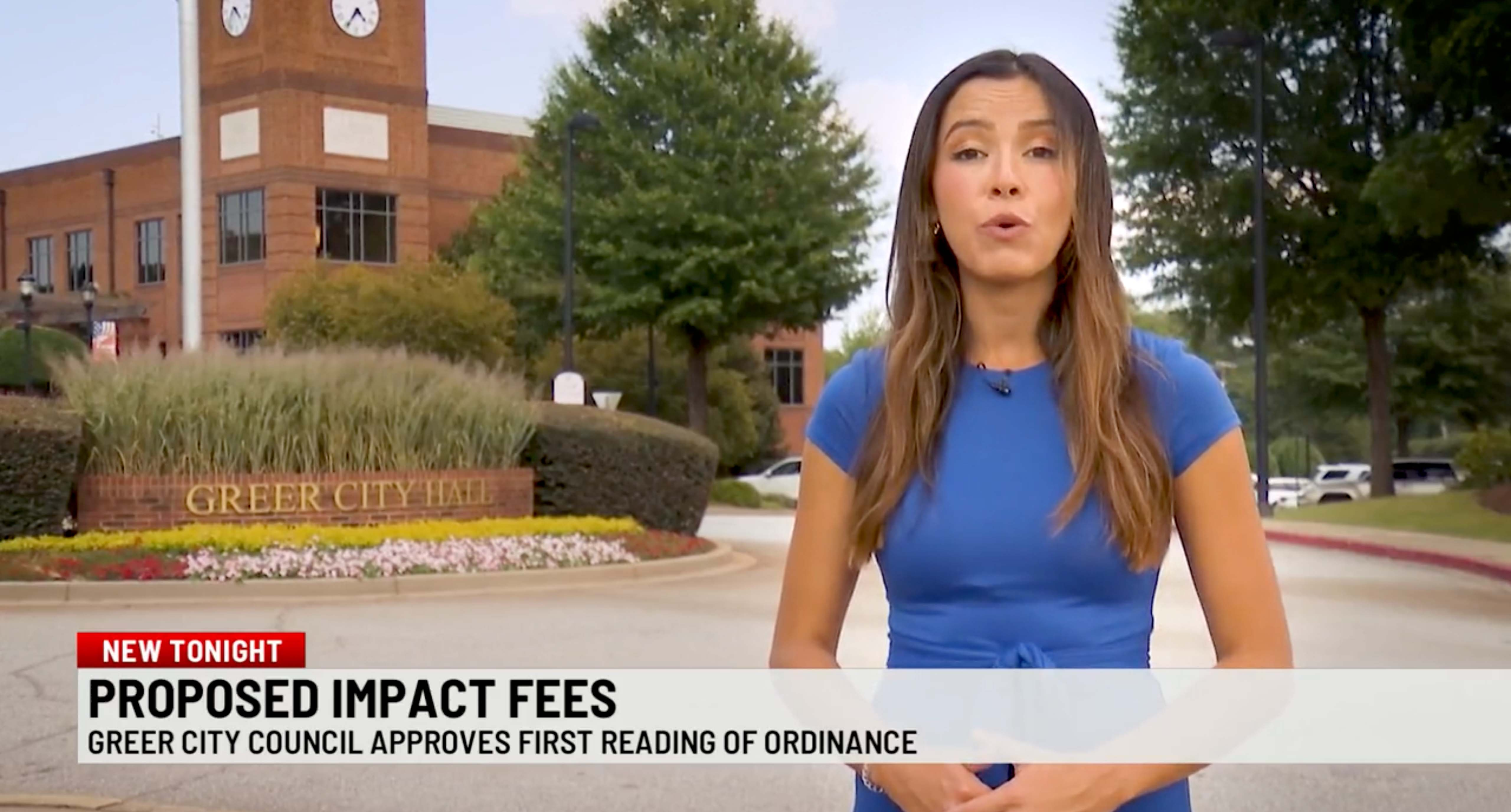 wspa reporter in front of greer city hall talking about proposed impact fees