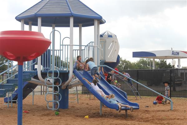 children playing on blue and white playground structure