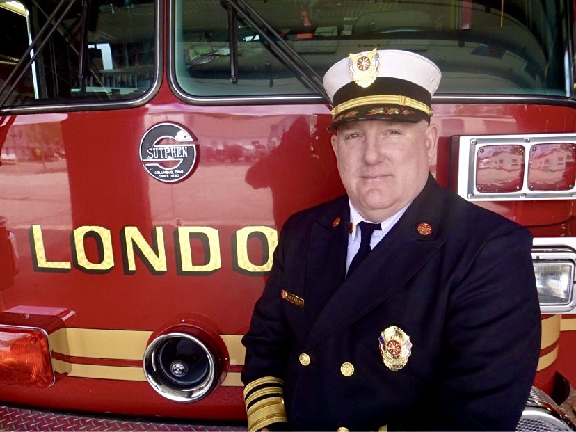 photo of Chief Todd Eades standing in front of a London city fire truck.