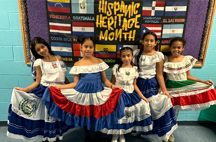 four girls wearing traditional dresses from the Latin culture