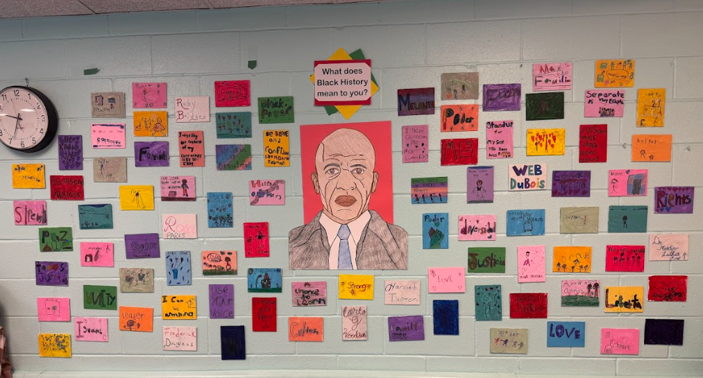 drawings from kindergarten about black history posted on a large wall