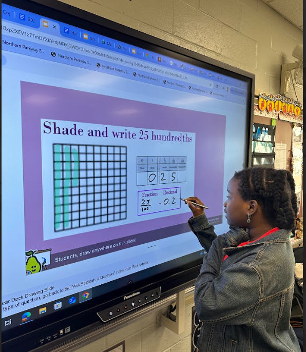 a student completing her math work on the screen