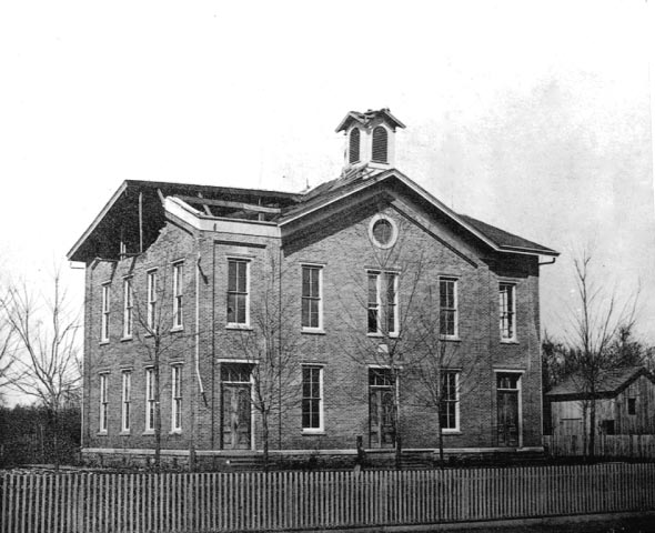 A black and white photo of the original school's building.