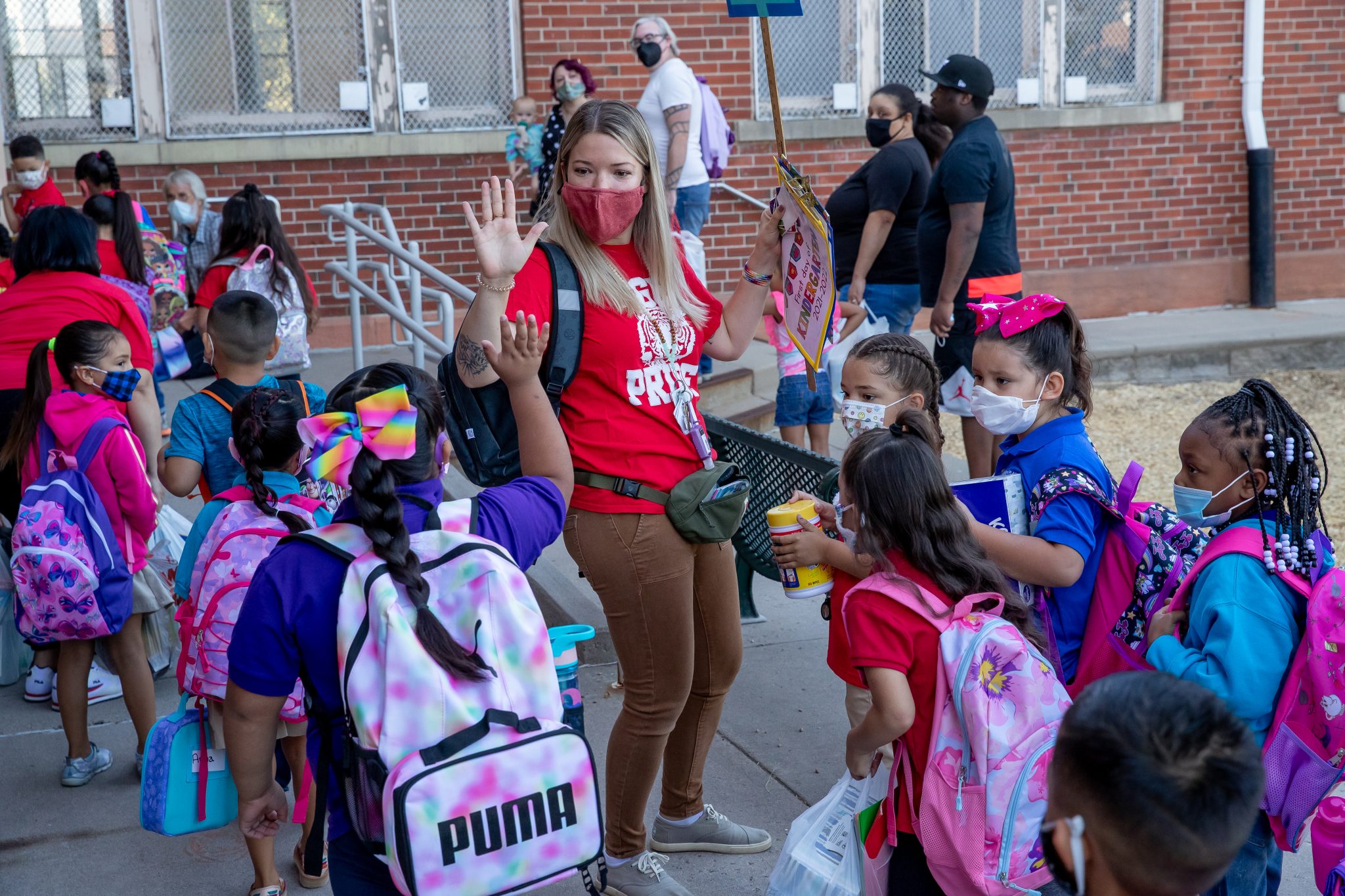 students and teacher entering school