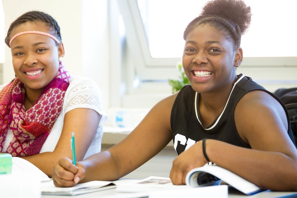 Students sitting around table smiling