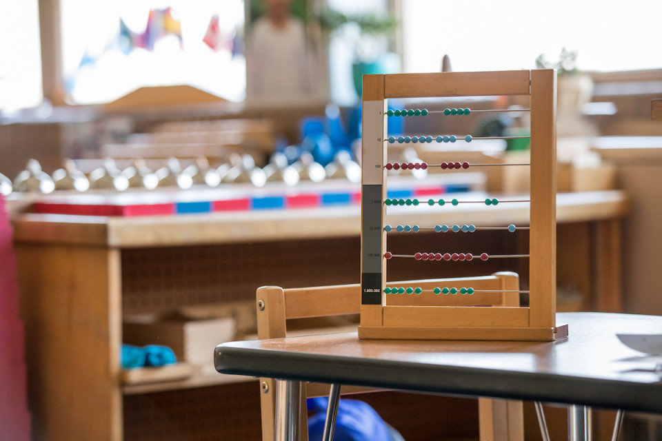 A bright sunny classroom with bookshelves and an abacus
