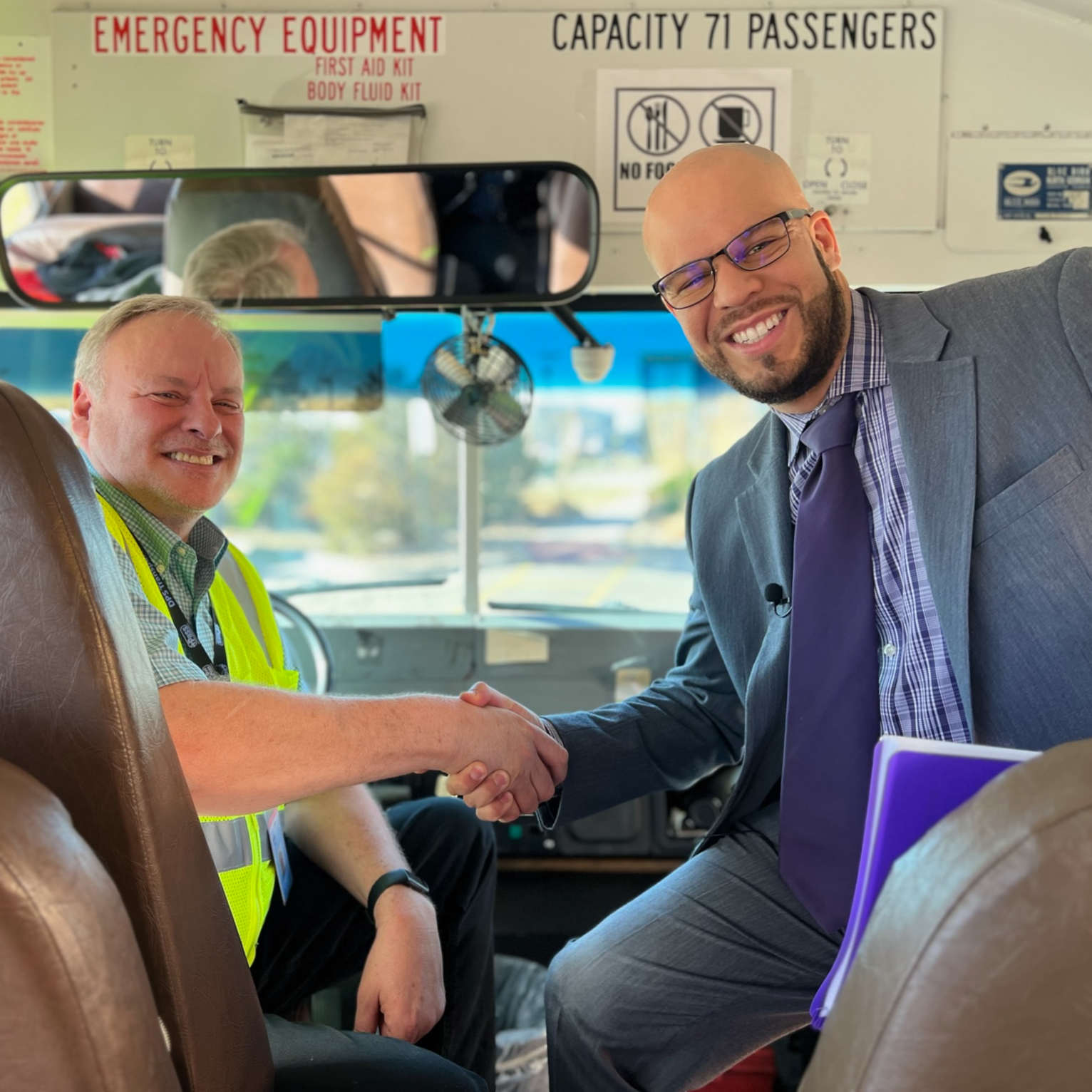 Dr. Marrero shaking hands with bus driver