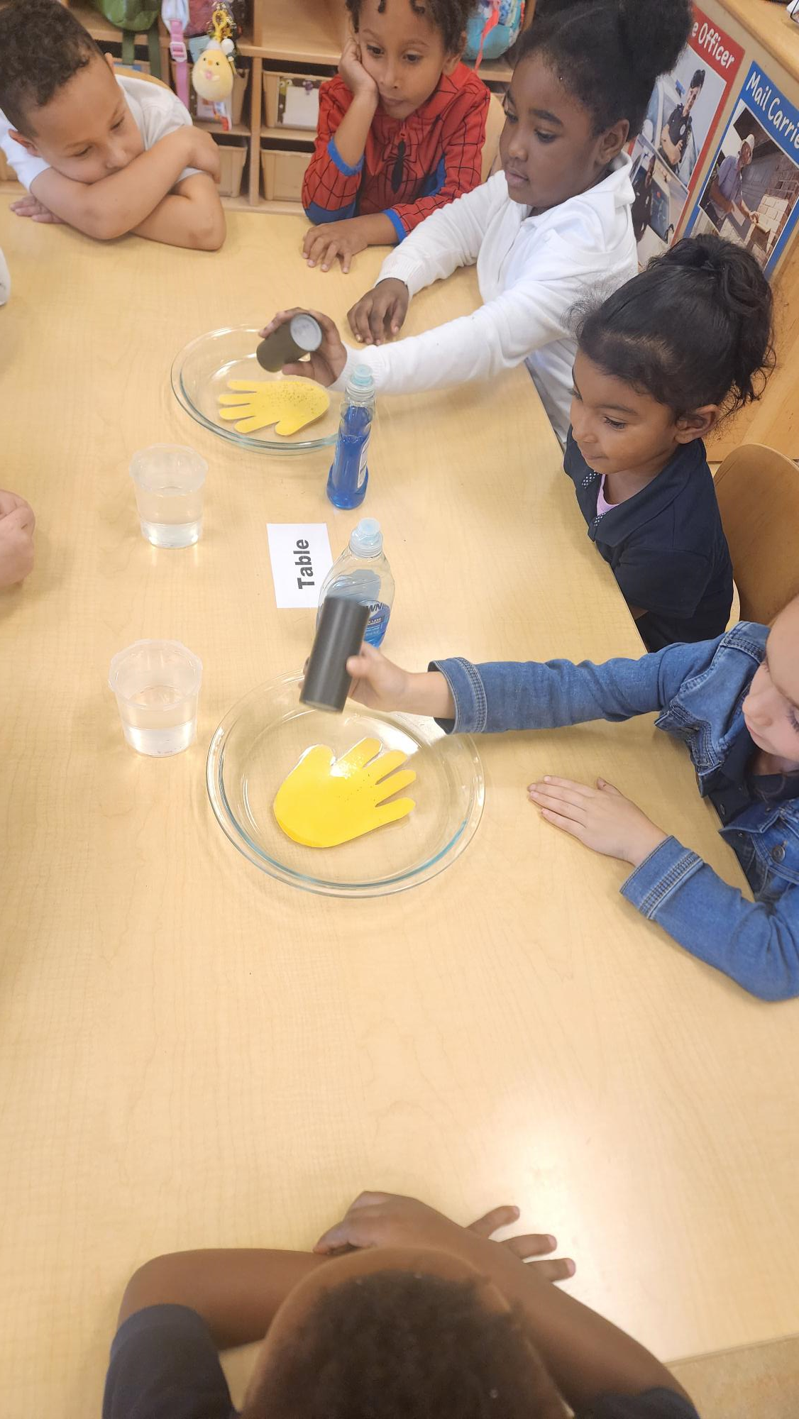 kids with hands in bowl at a table