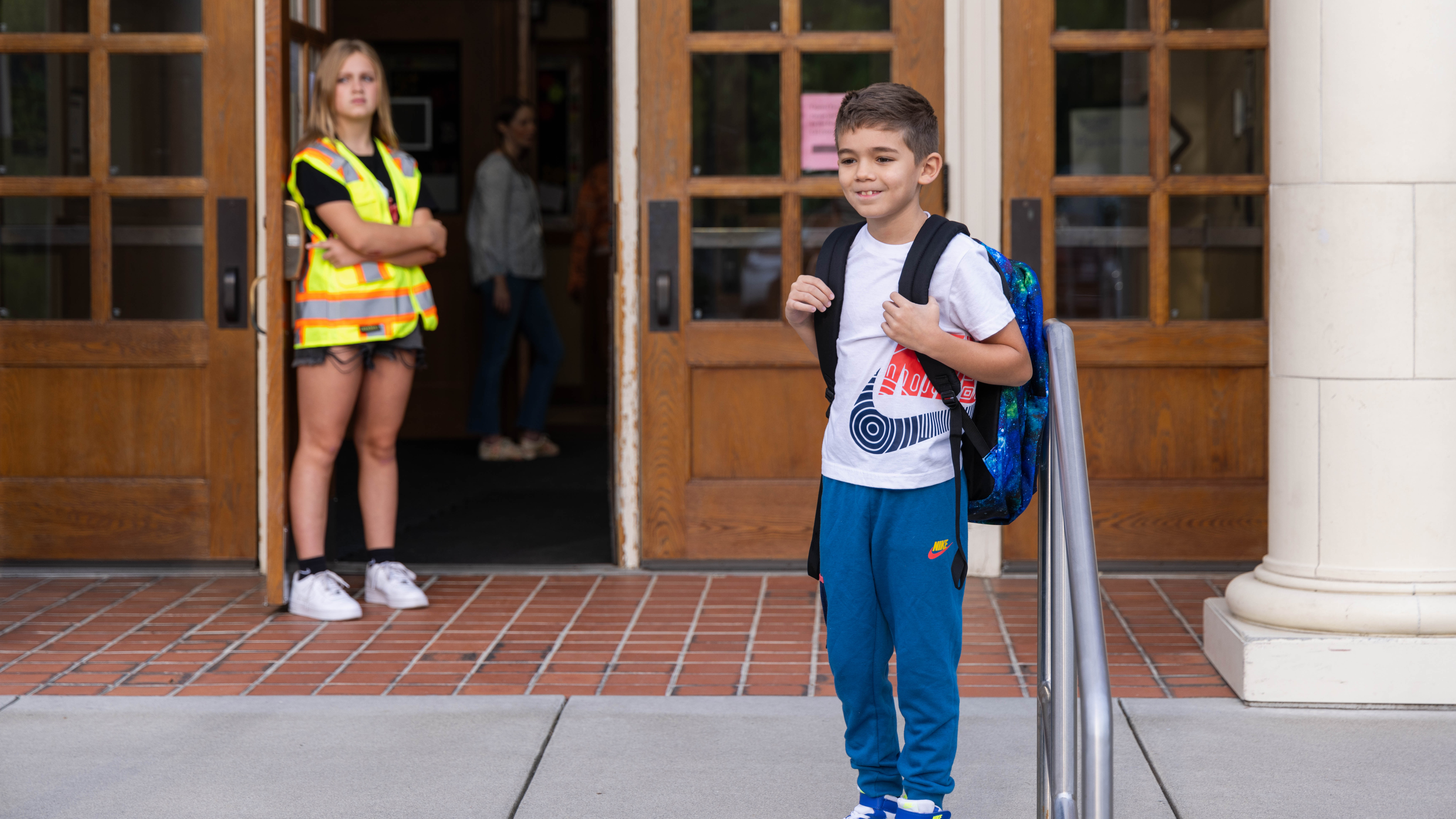 Student smiling on first day of school on school steps
