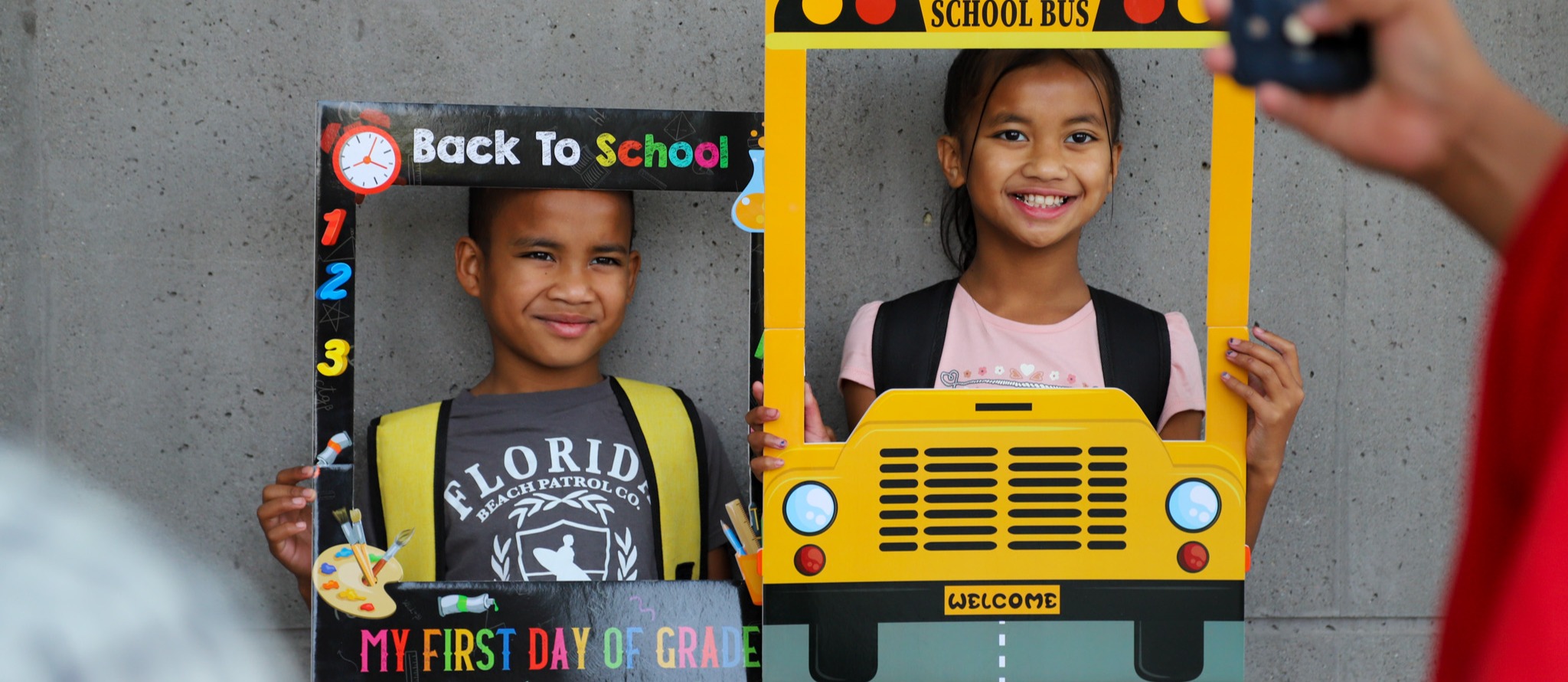 Student smiling on first day of school on school steps
