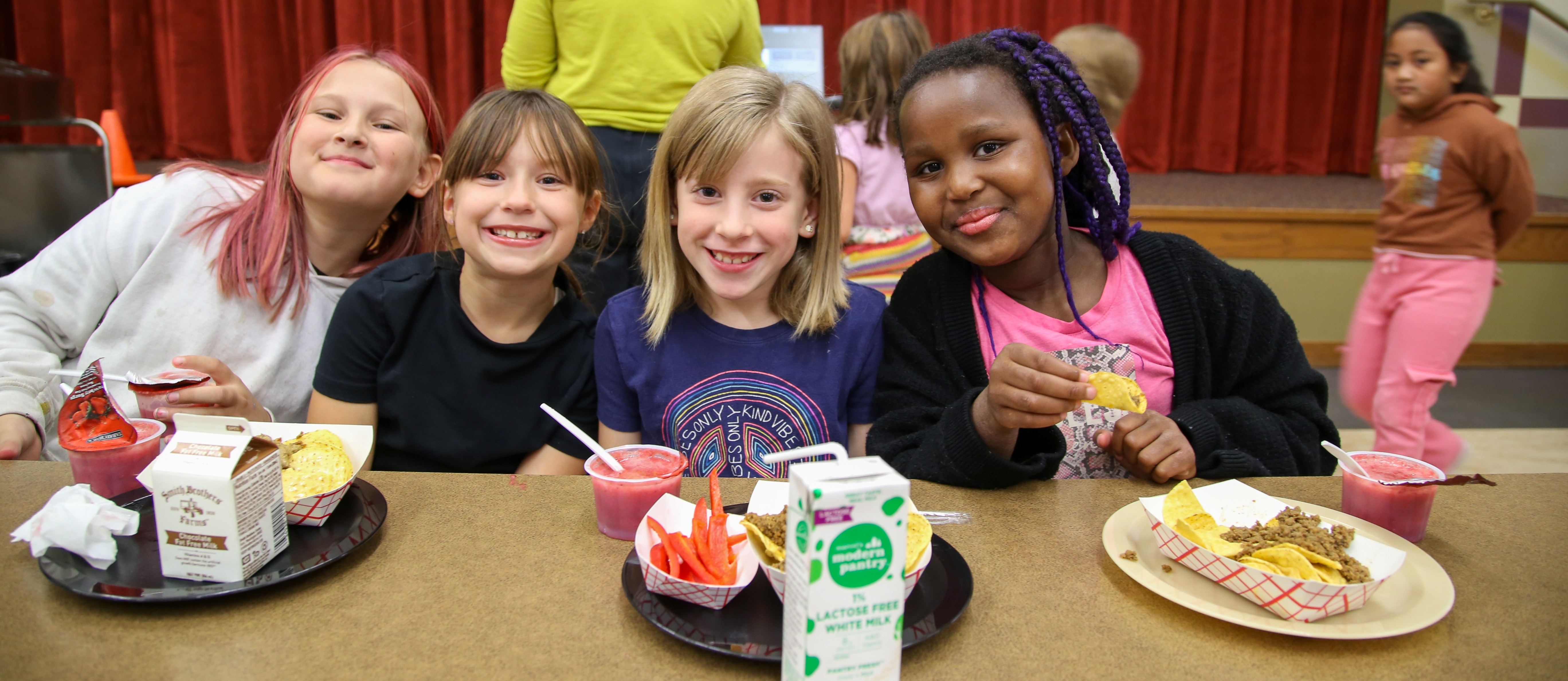 Four smiling female students at lunch