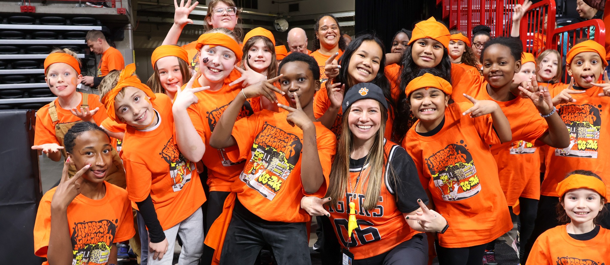 Kids in orange shirts posing