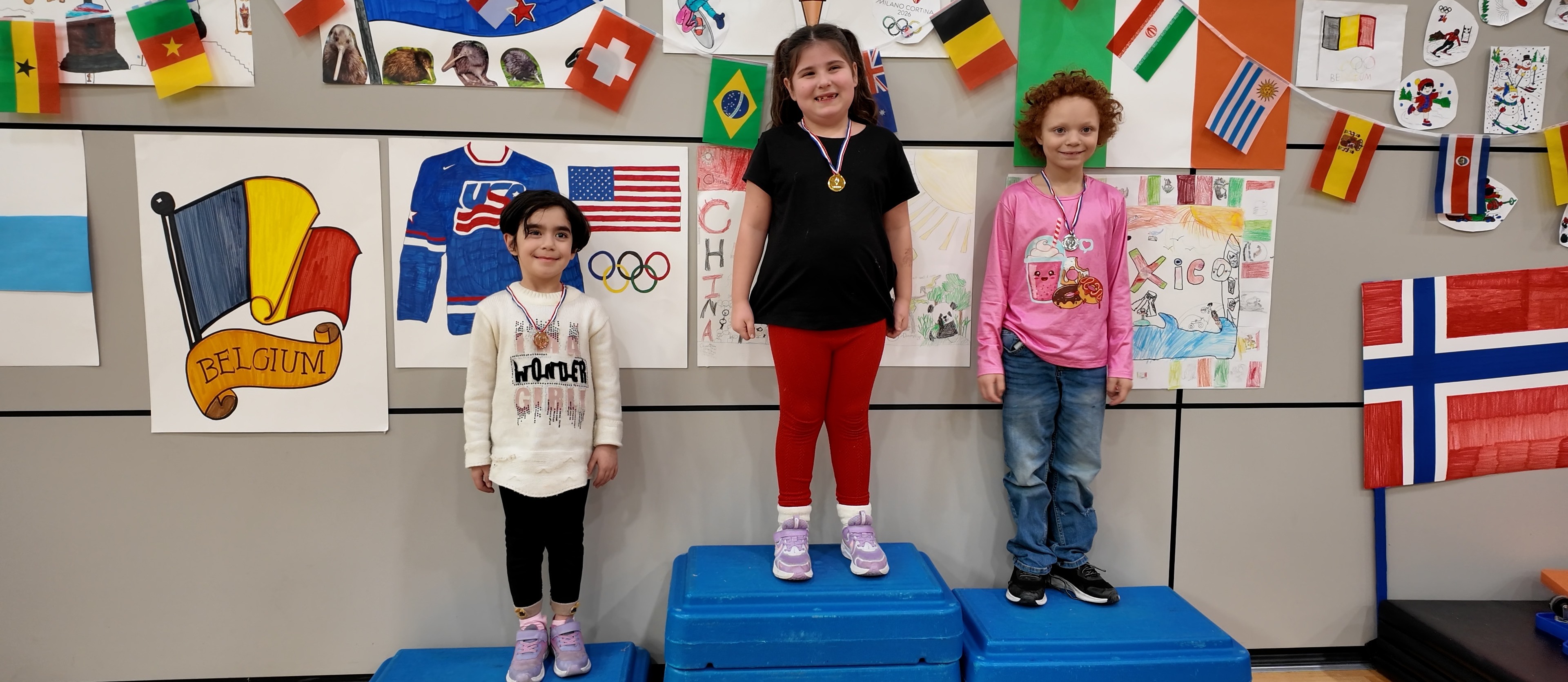 Students smiling on olympic podium in P.E. class