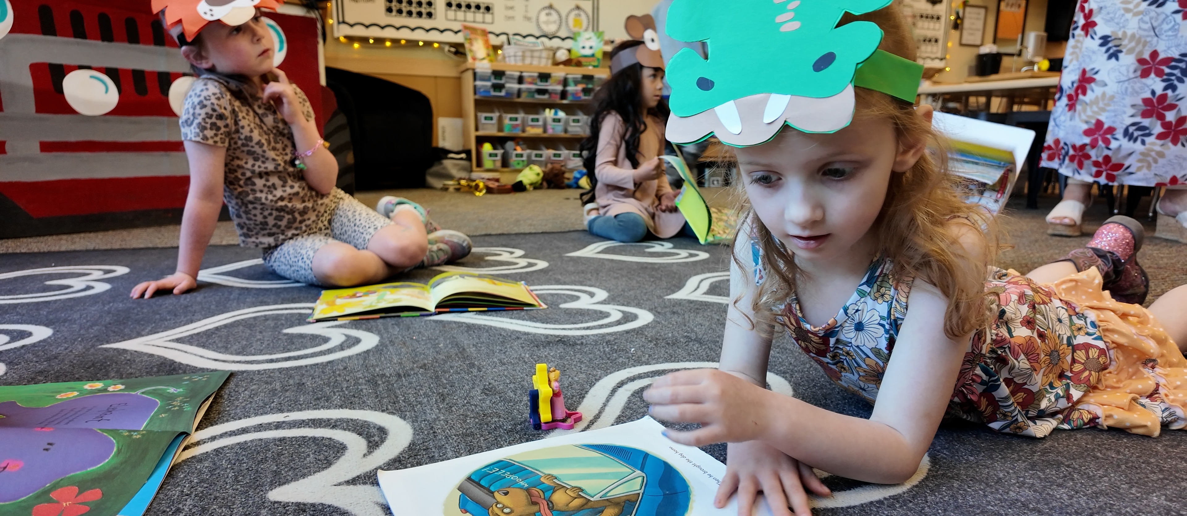 Preschool student reading a book on the carpet