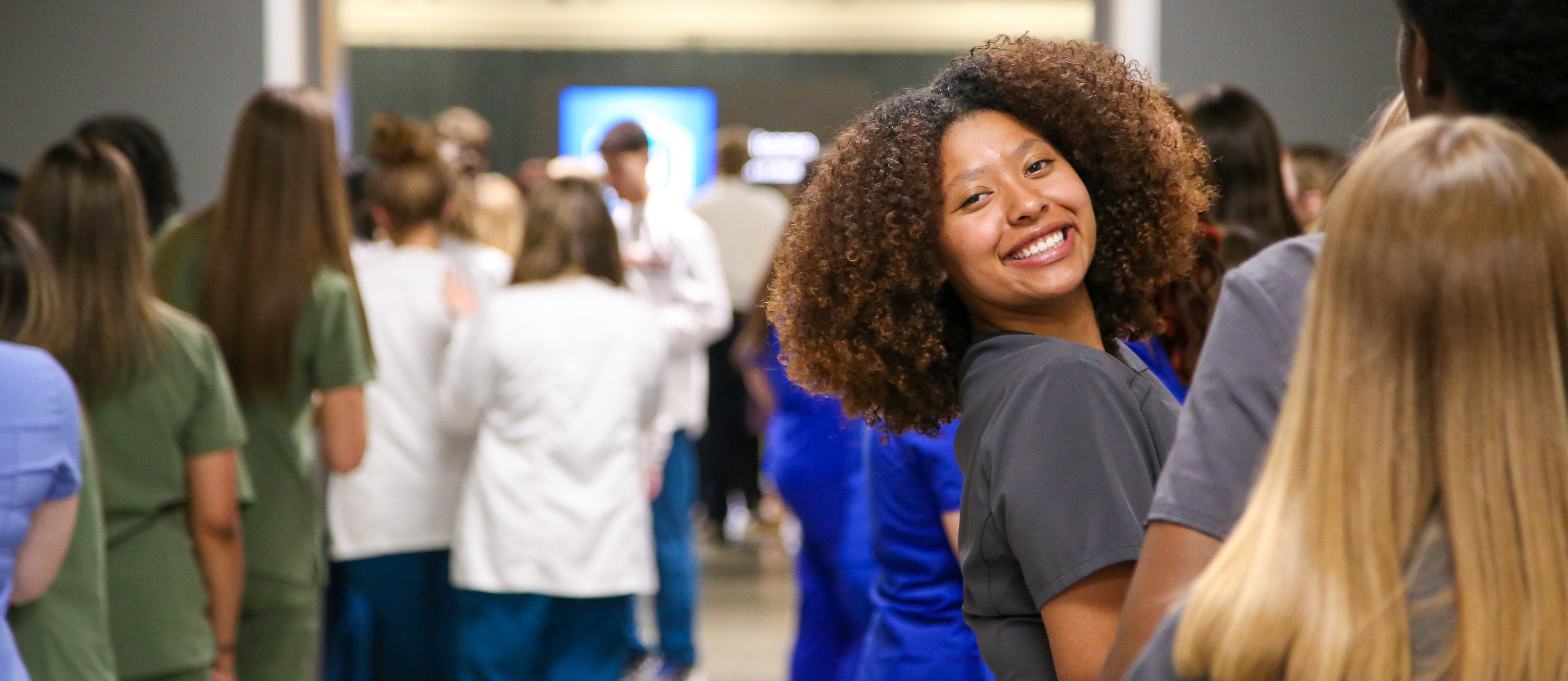 Girl in line looking back at camera and smiling