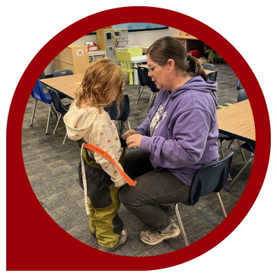 Paraeducator helping a student with their snow gear