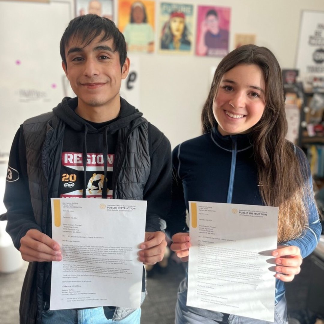 Two high school students holding letters for award notification