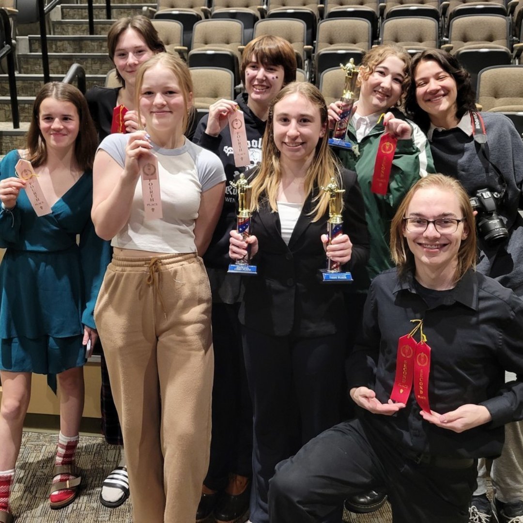 Group of high school students hold awards from a CTE competition