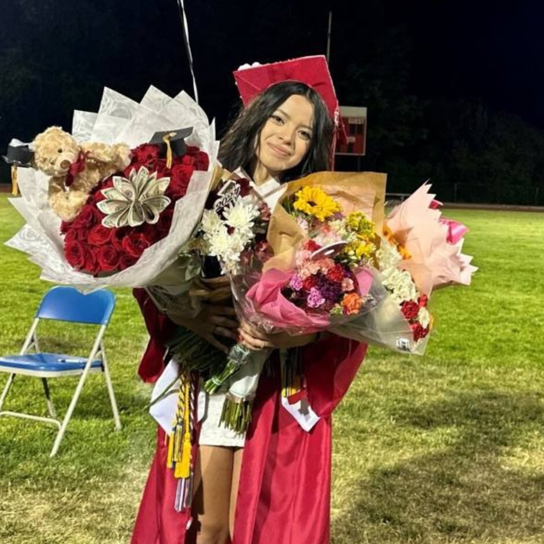 Cascade High School graduate holding flowers while in her cap and gown