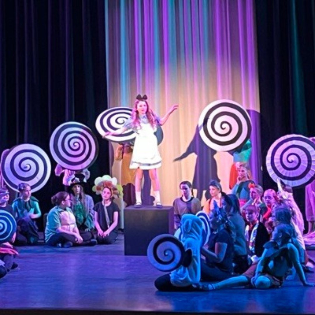 Students performing Alice in Wonderland Jr on stage