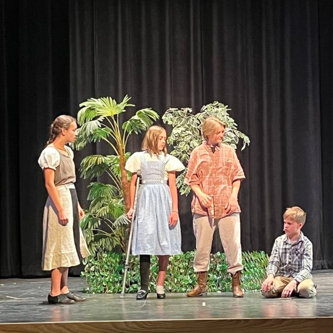Three students on stage performing