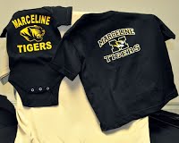 A baby onesie and a shirt with the school's logo.