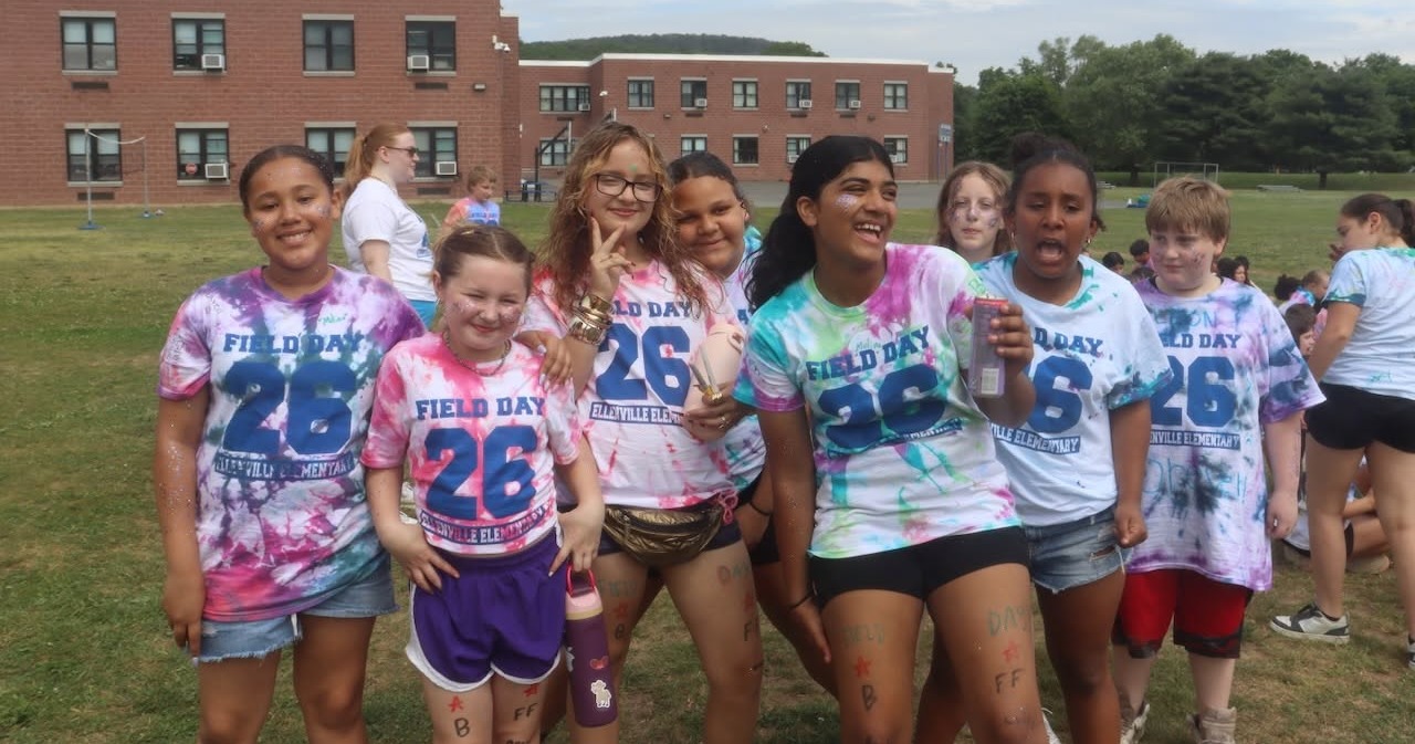 A group of kids outside smiling and laughing