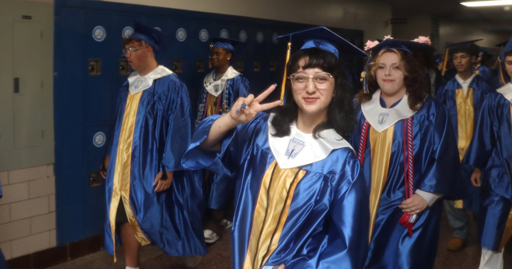 A graduate giving the peace sign