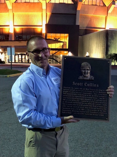photo of scott collins holding up a plaque of himself