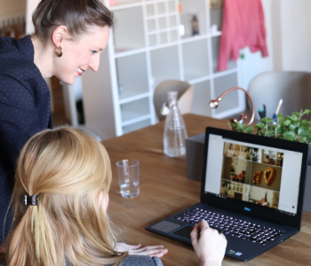 two women collaborating on a laptop together