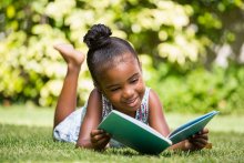 Little girl reading at the garden