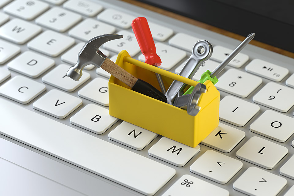 Miniature toolbox sitting on a computer keyboard