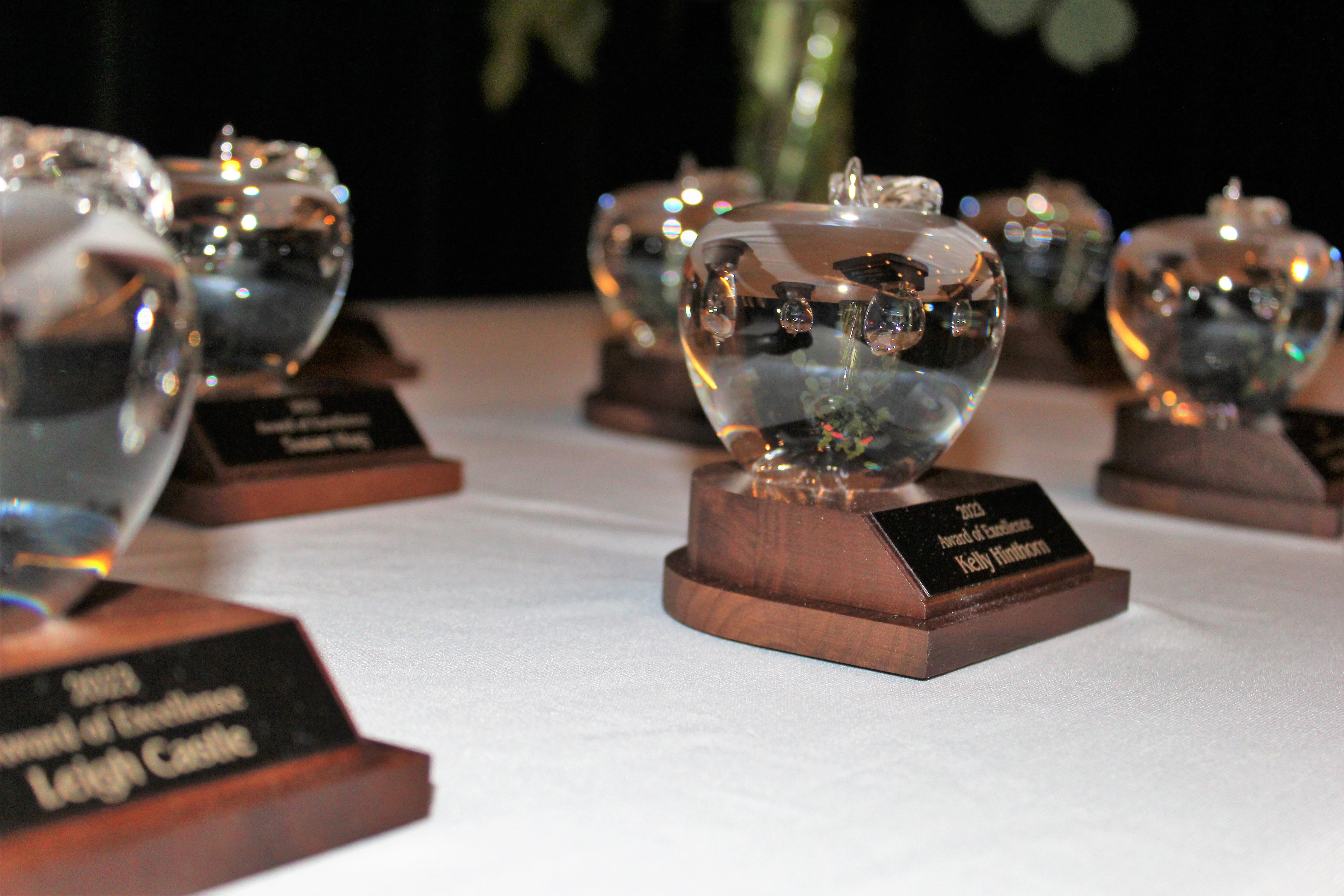 crystal apple awards are lined up on a table