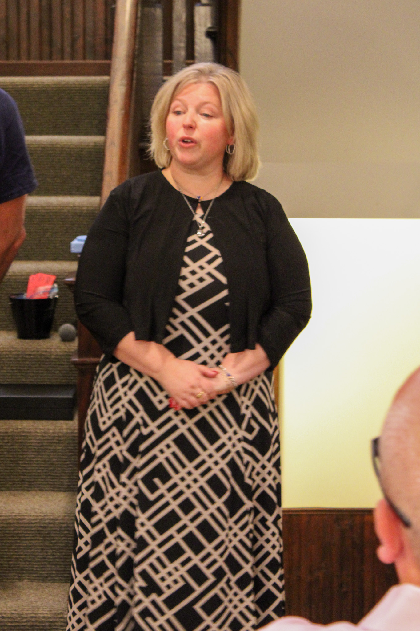 woman standing in front of stairway talking