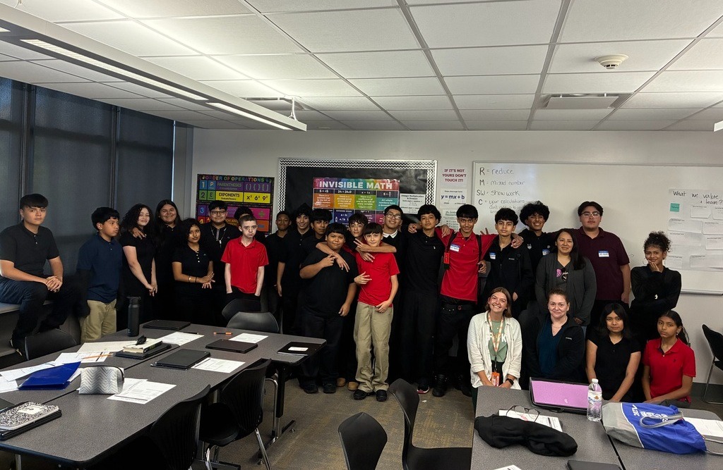 Group of students in classroom smiling at camera