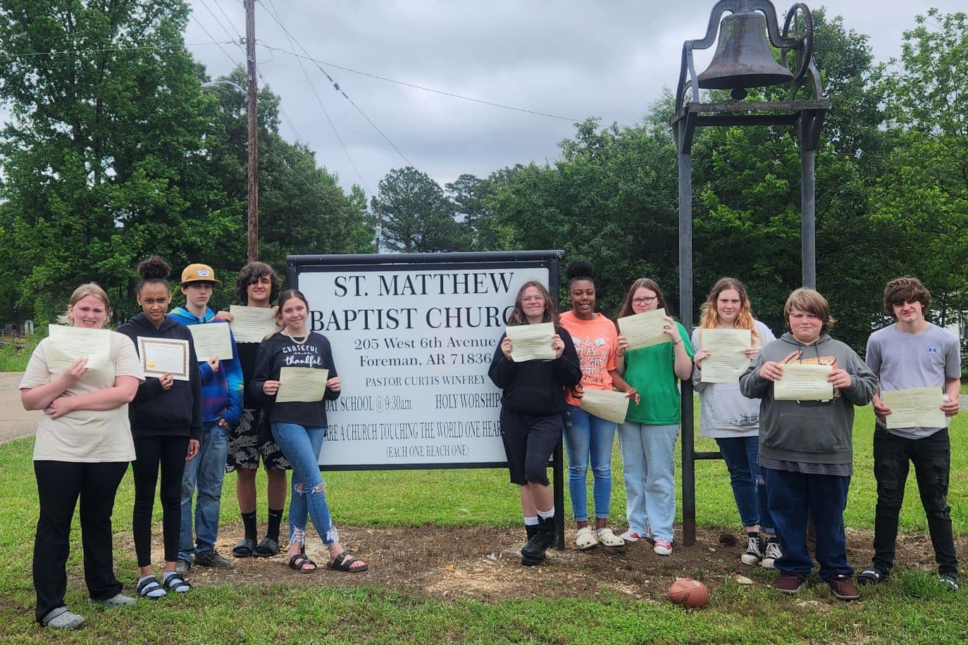 Students standing outside with certificates in hand