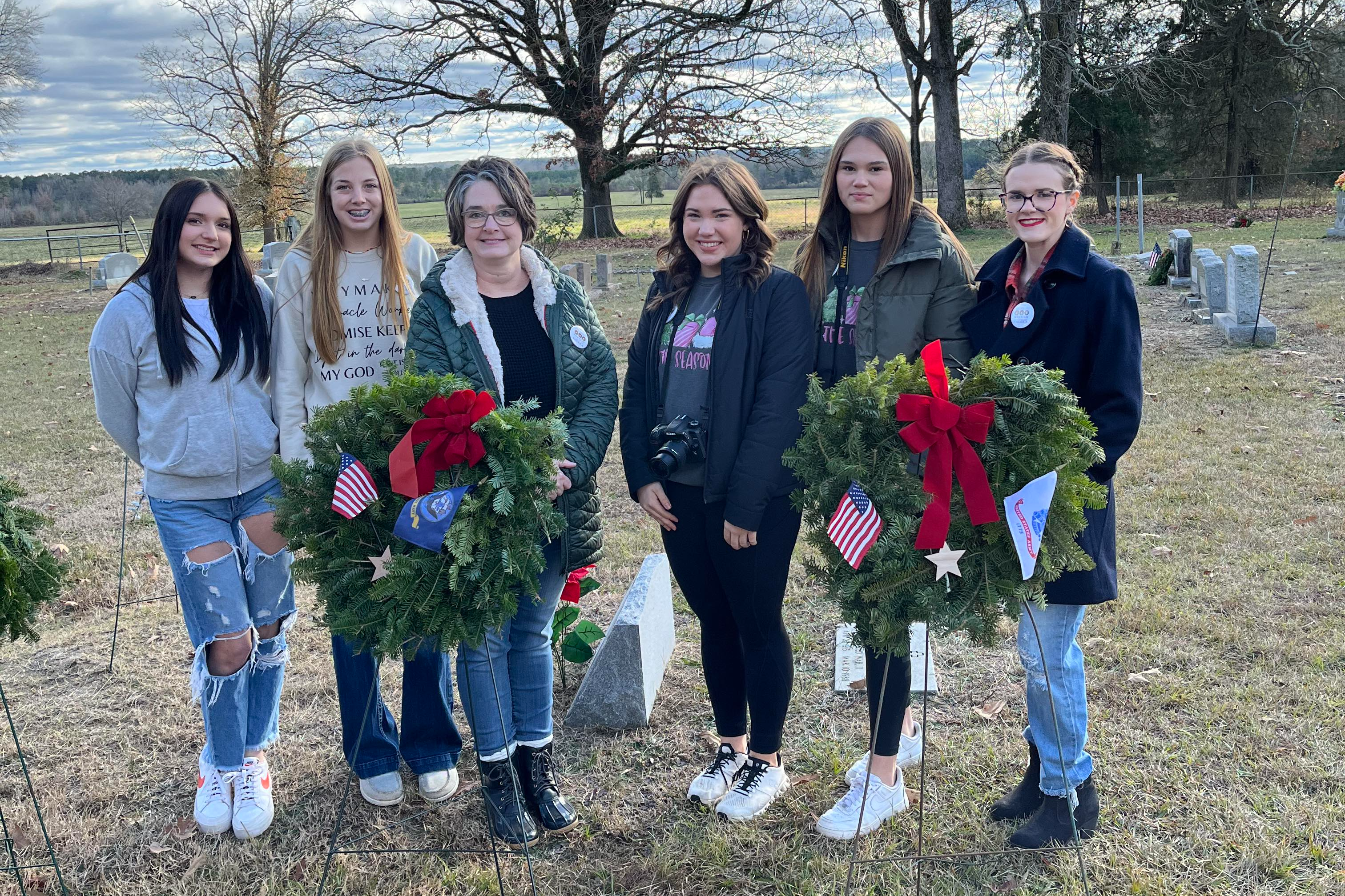 students standing behind wreaths