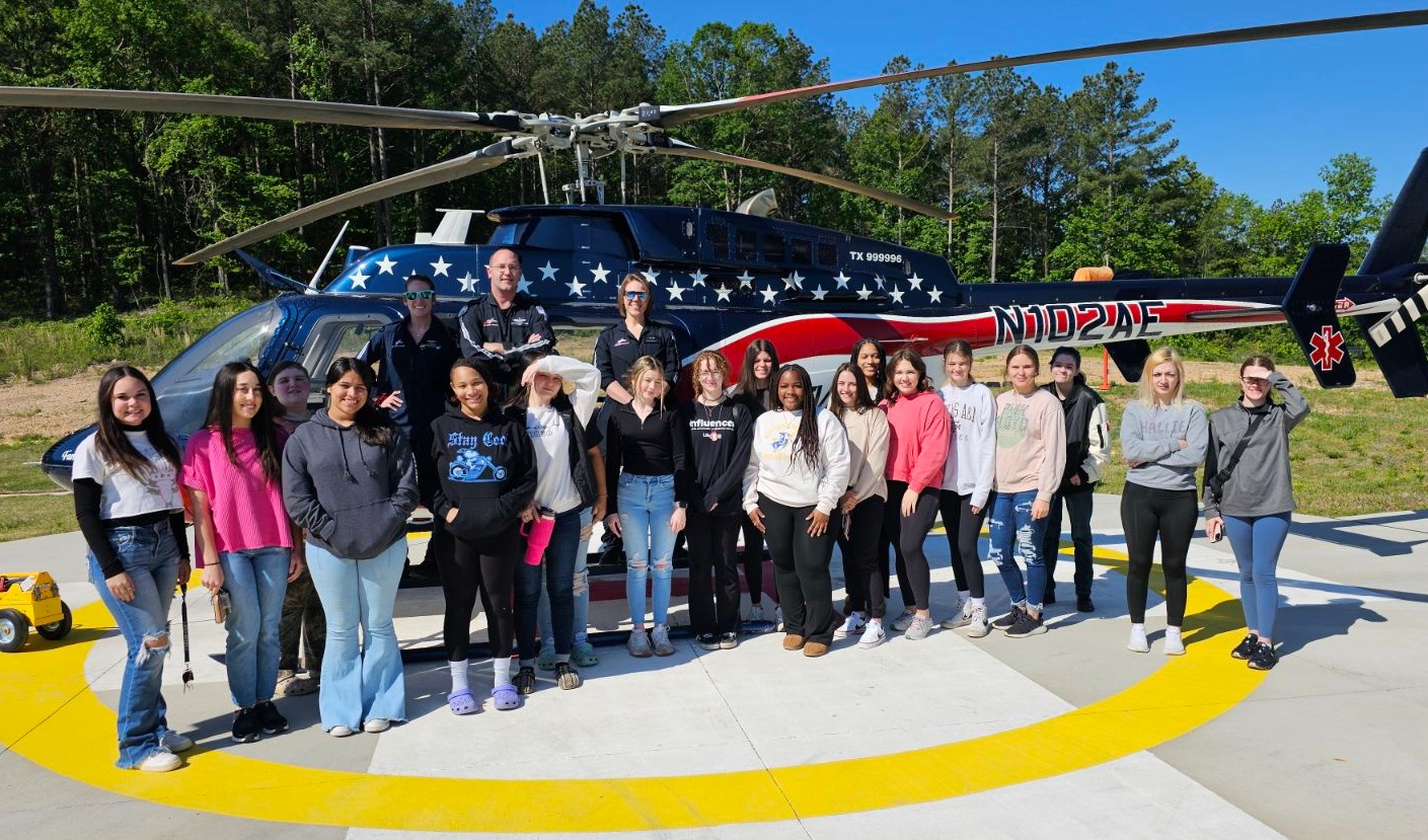 Students standing in front of a helicopter