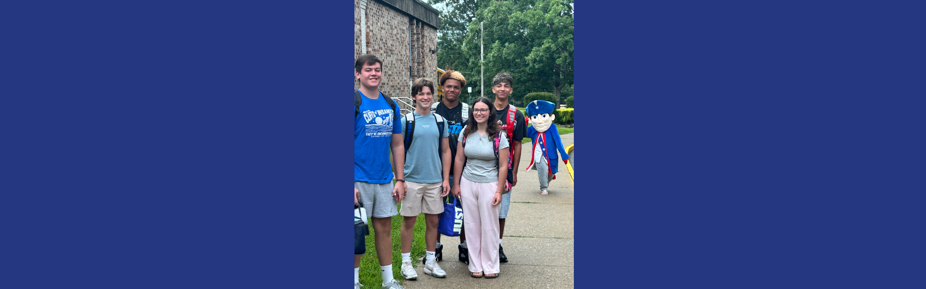 Five Lenape Valley Regional High School students pose together outside the school with the Patriot mascot during the first days of the school year.