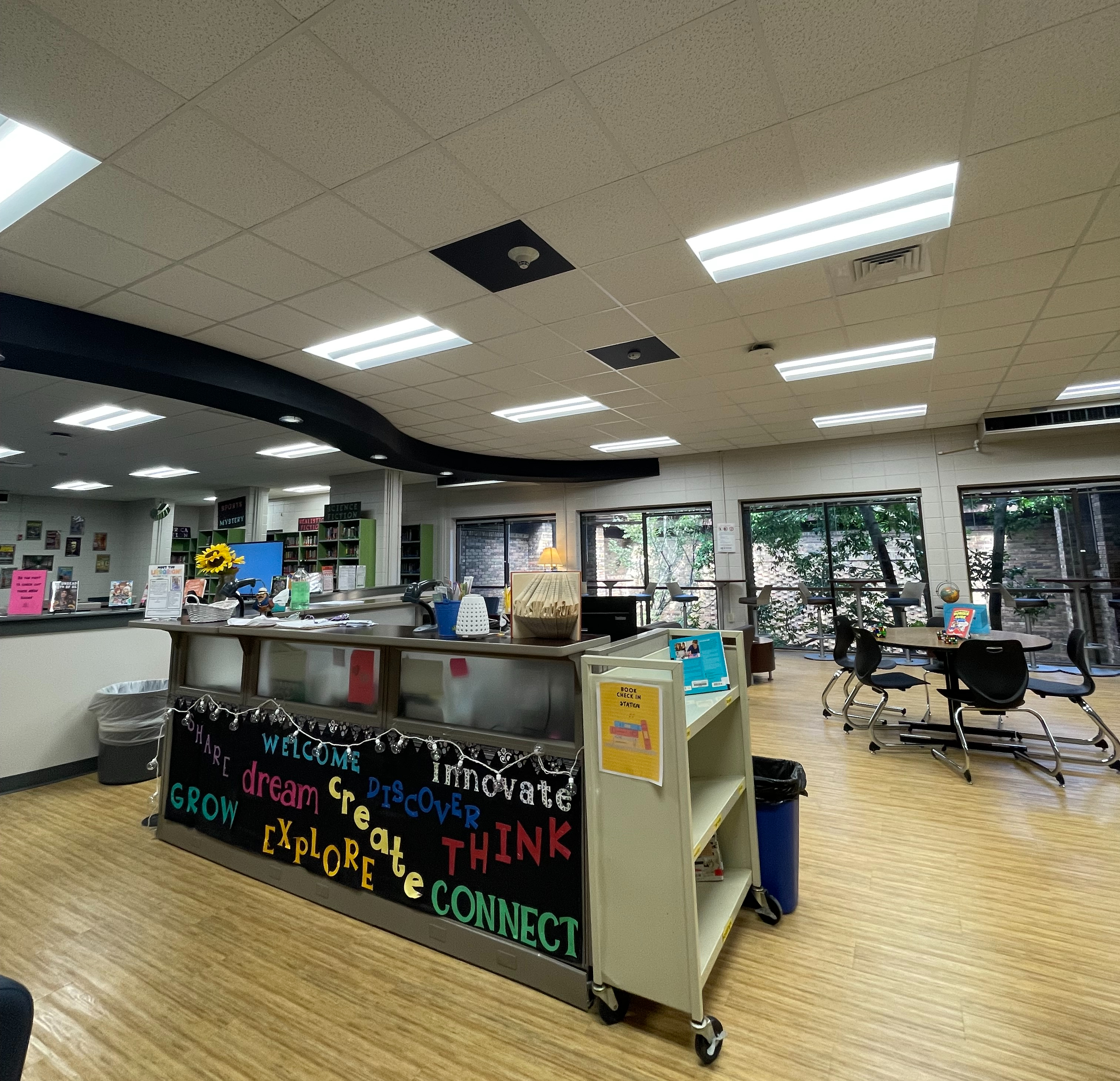 View of the HJHS library which includes a collection case, front desk, and various books