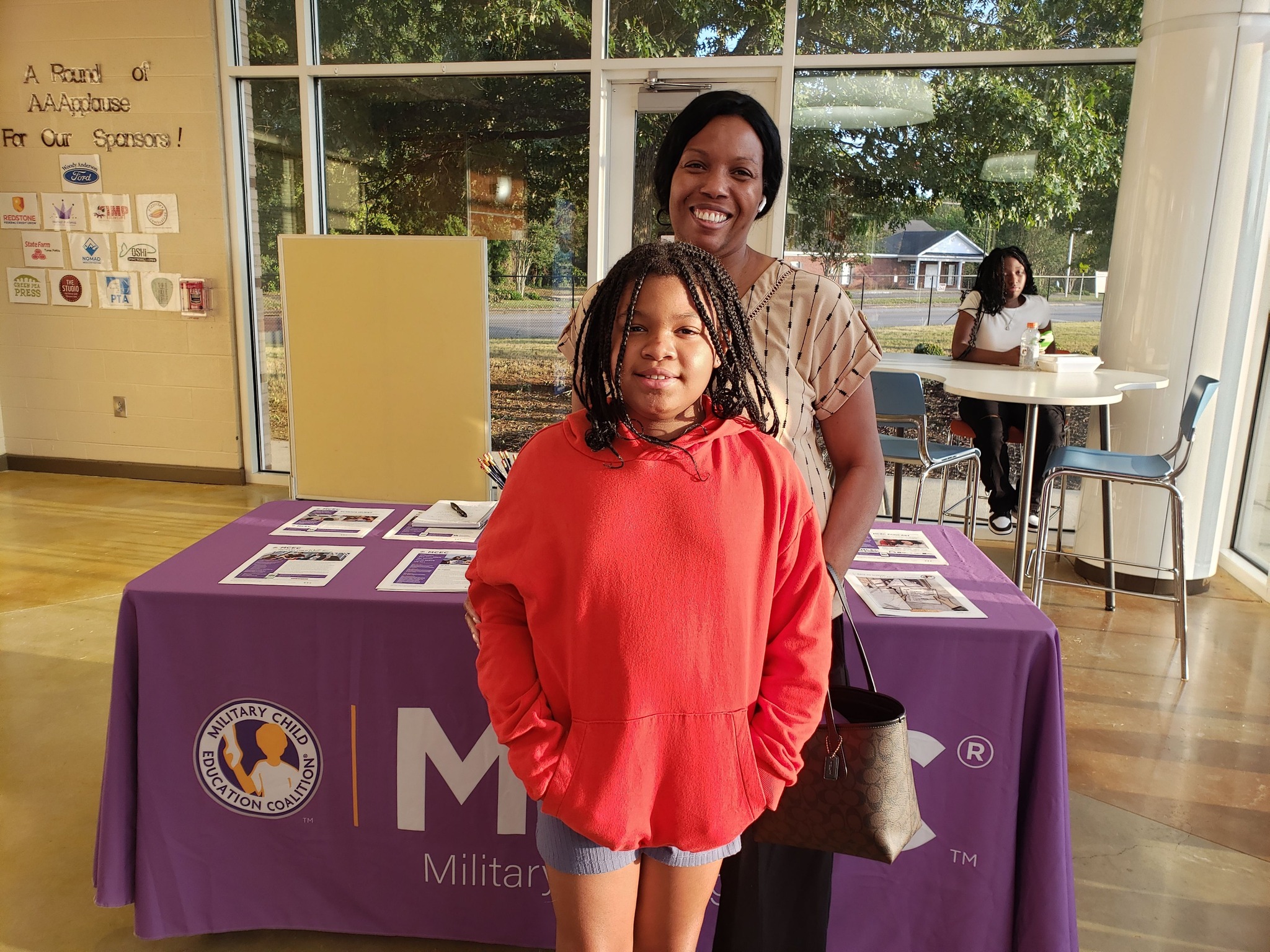 Woman and girl standing in front of table