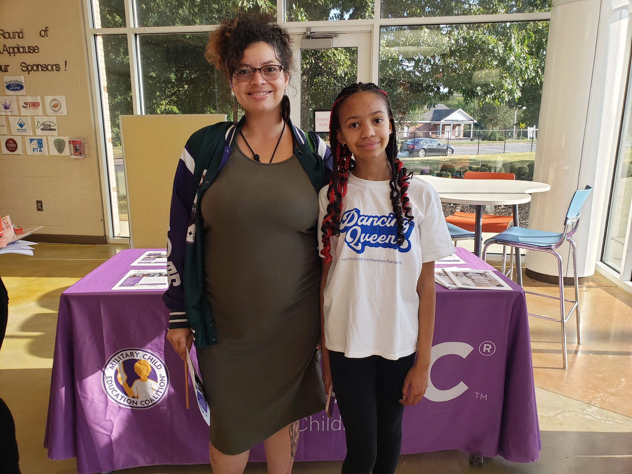 Woman and girl standing in front of table