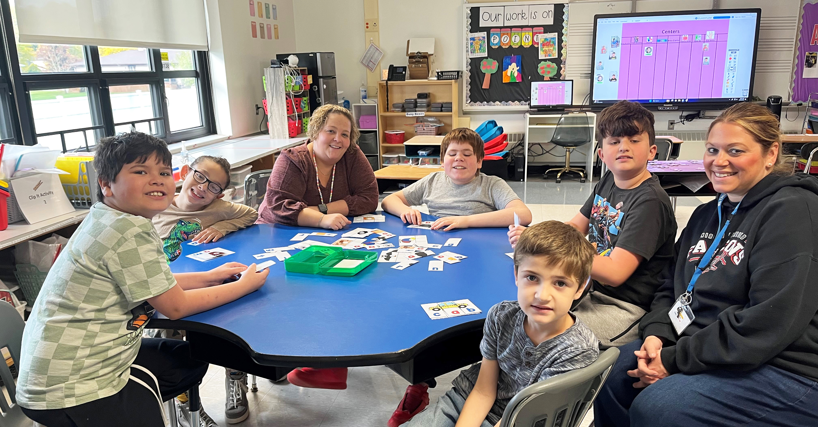 Teacher at table with students 